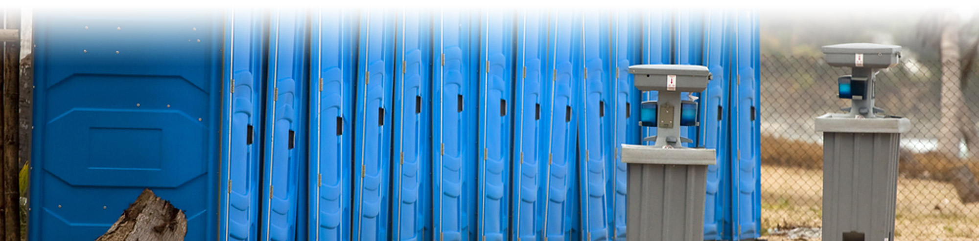 Portable sinks / hand wash stations near a row of blue porta potties
